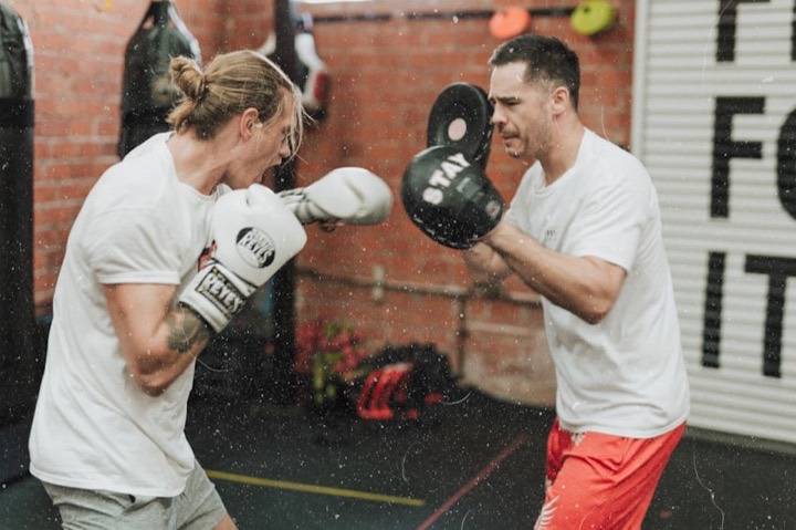 Coaching professionnel à L'Atelier du Combat, Seichamps : coach tenant les pattes d'ours pendant un entraînement de boxe